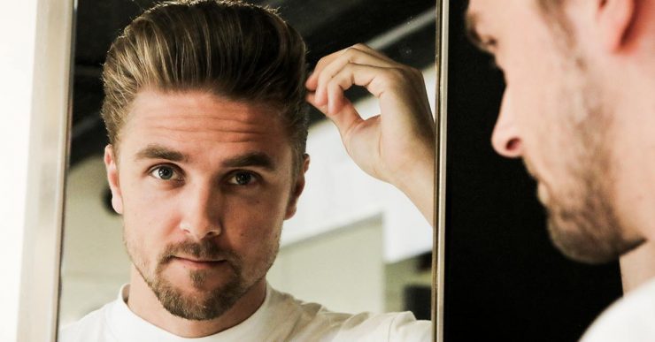 Man checking his hairstyle in a mirror