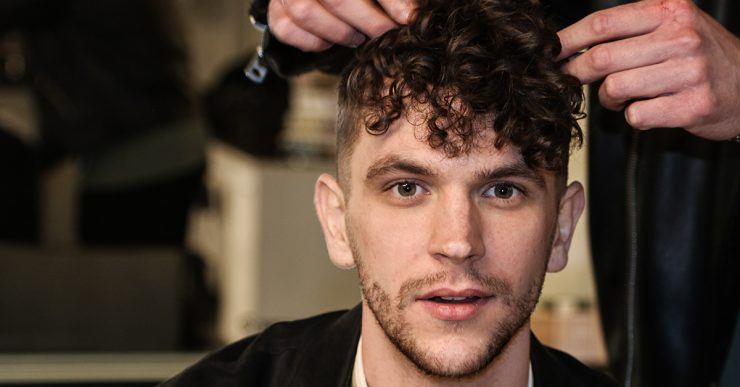Stylist shaping curls above shorter sides
