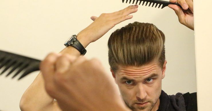 Man shaping a swept-back hairstyle with a wide-tooth comb