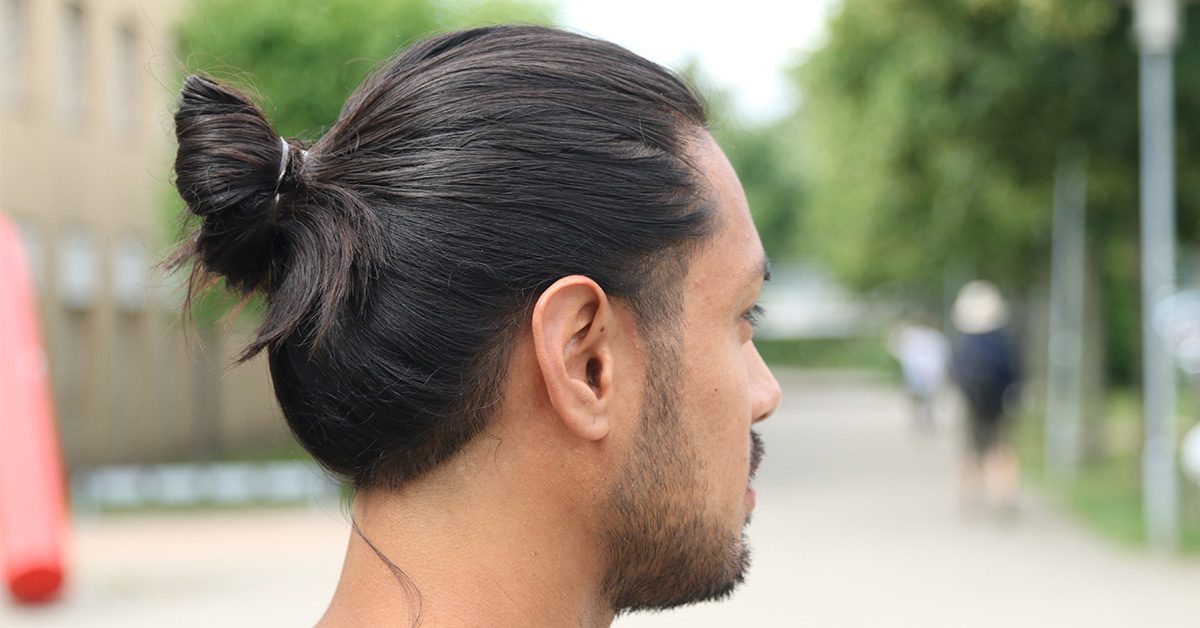 Full man bun tied at the back of long hair